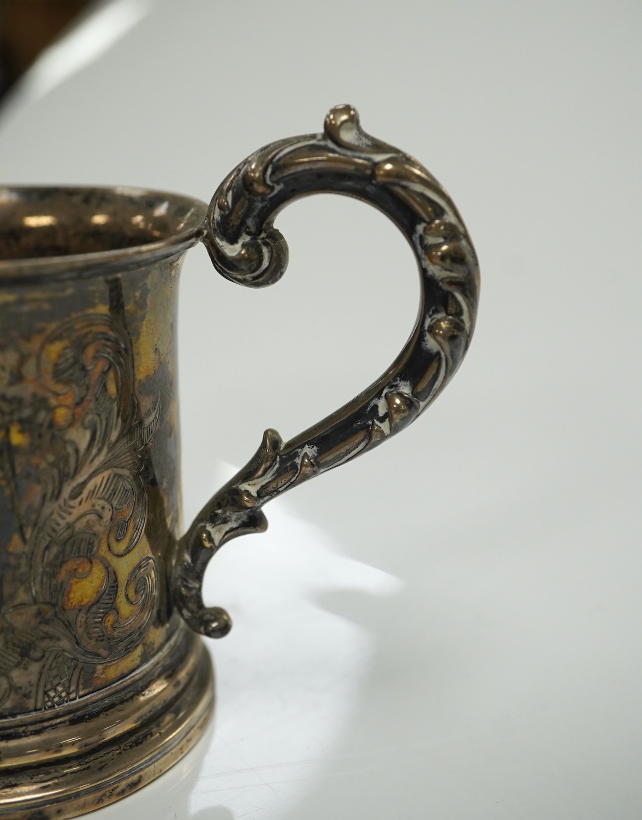 A George V Brittania standard silver kitchen pepper, by John Charles Lowe, London, 1935, 11.5cm and a Victorian silver christening mug, 10.4oz. Condition - poor to fair